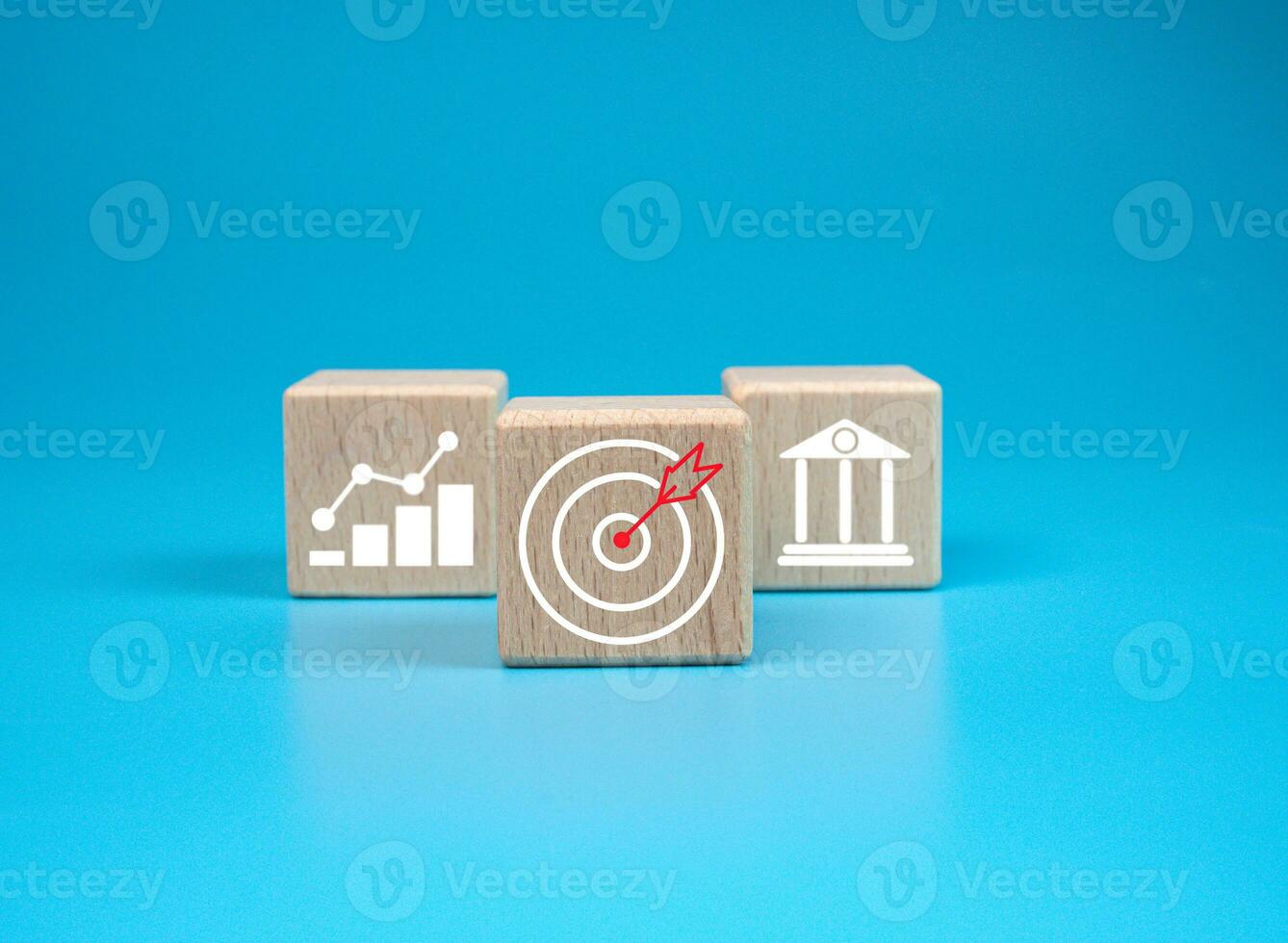 wooden block which prints a target icon and business symbol on light blue background. Business goals and objectives concept. business competition. business target concept. photo