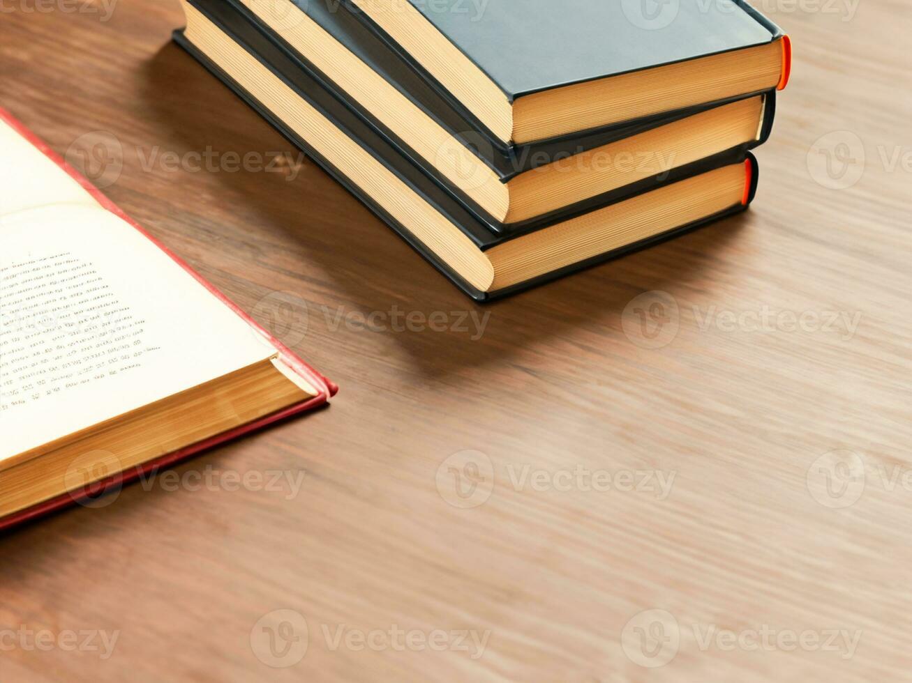 stack of books on wooden table against grey wall photo