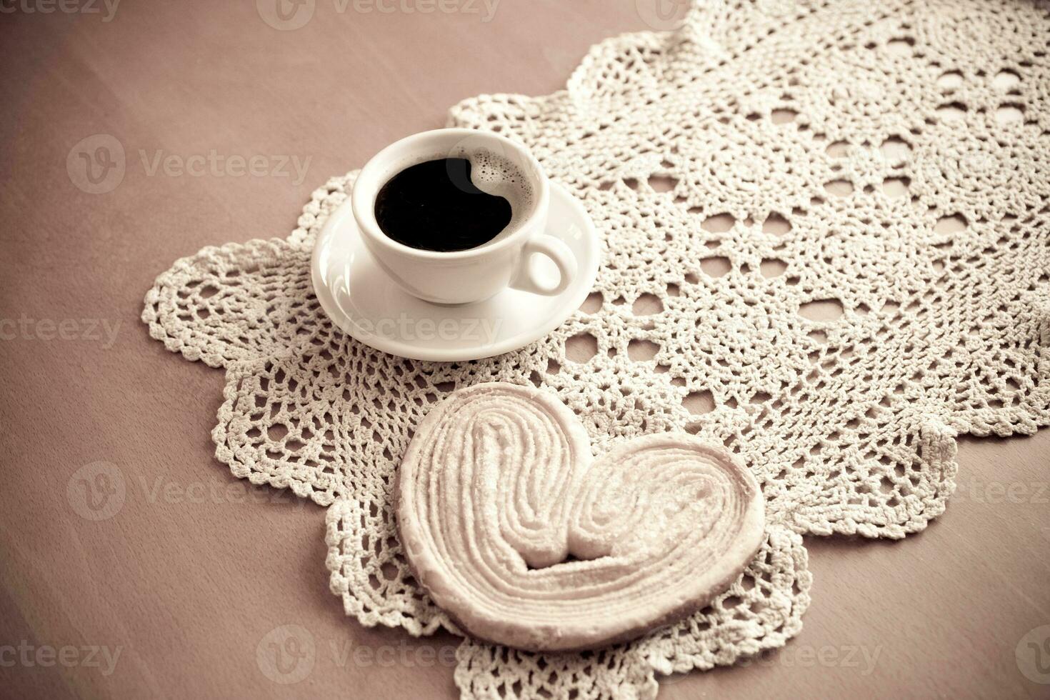 white cup of black coffee and a sweet buttery cookie on the table photo