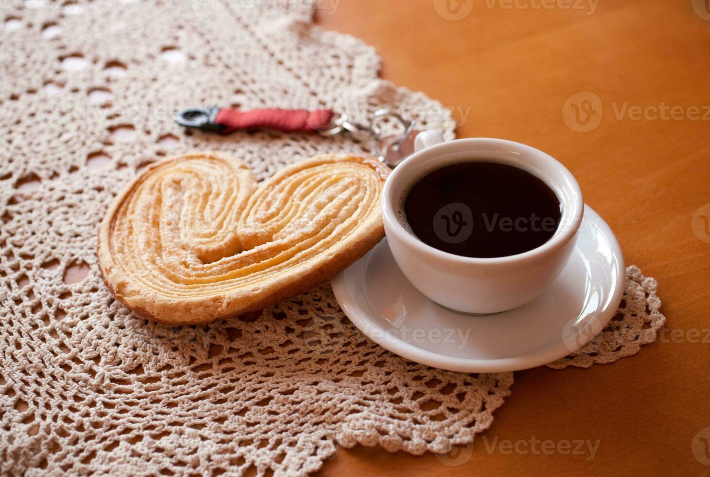 white cup of black coffee and a sweet buttery cookie on the table photo