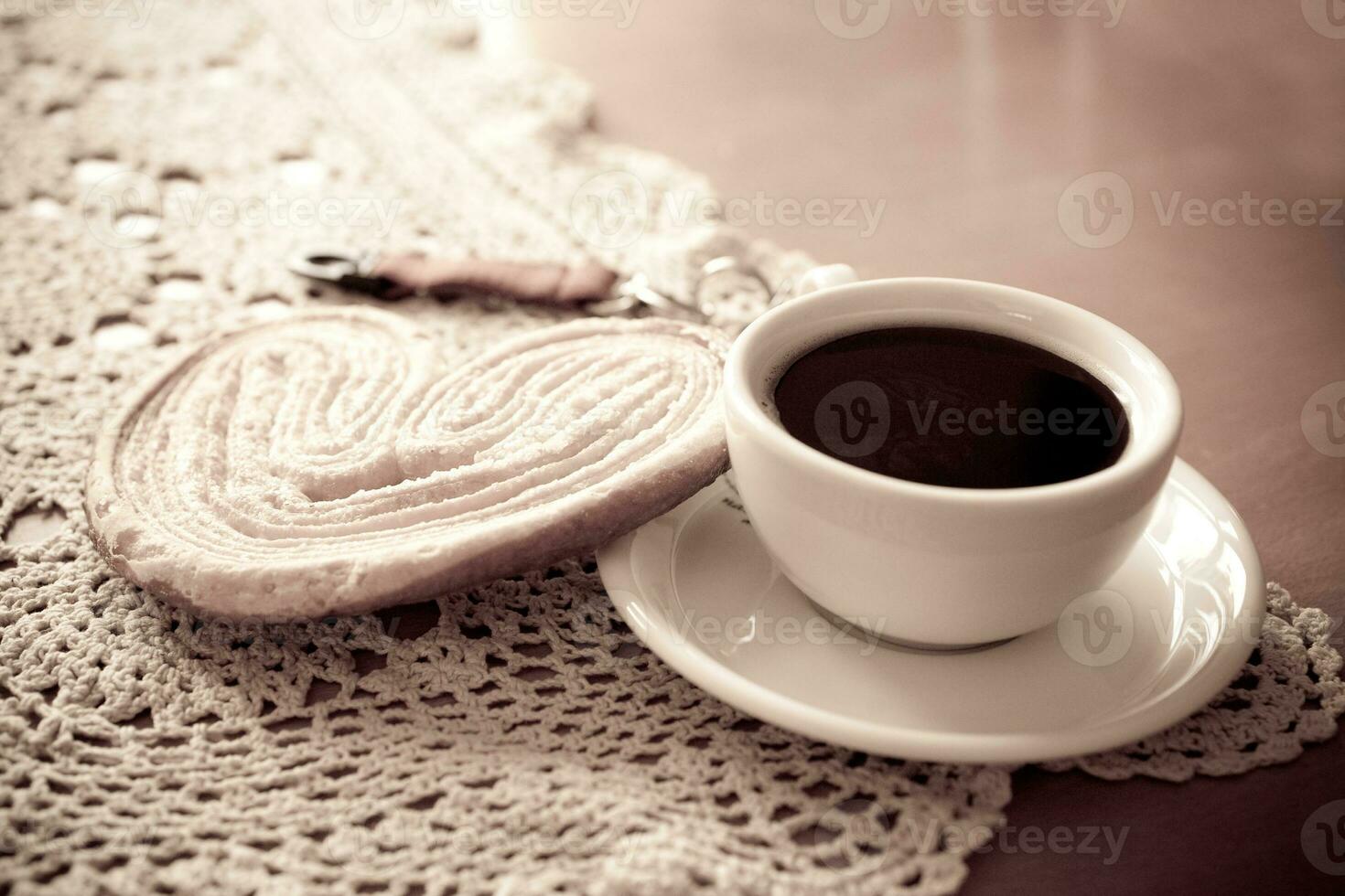 white cup of black coffee and a sweet buttery cookie on the table photo