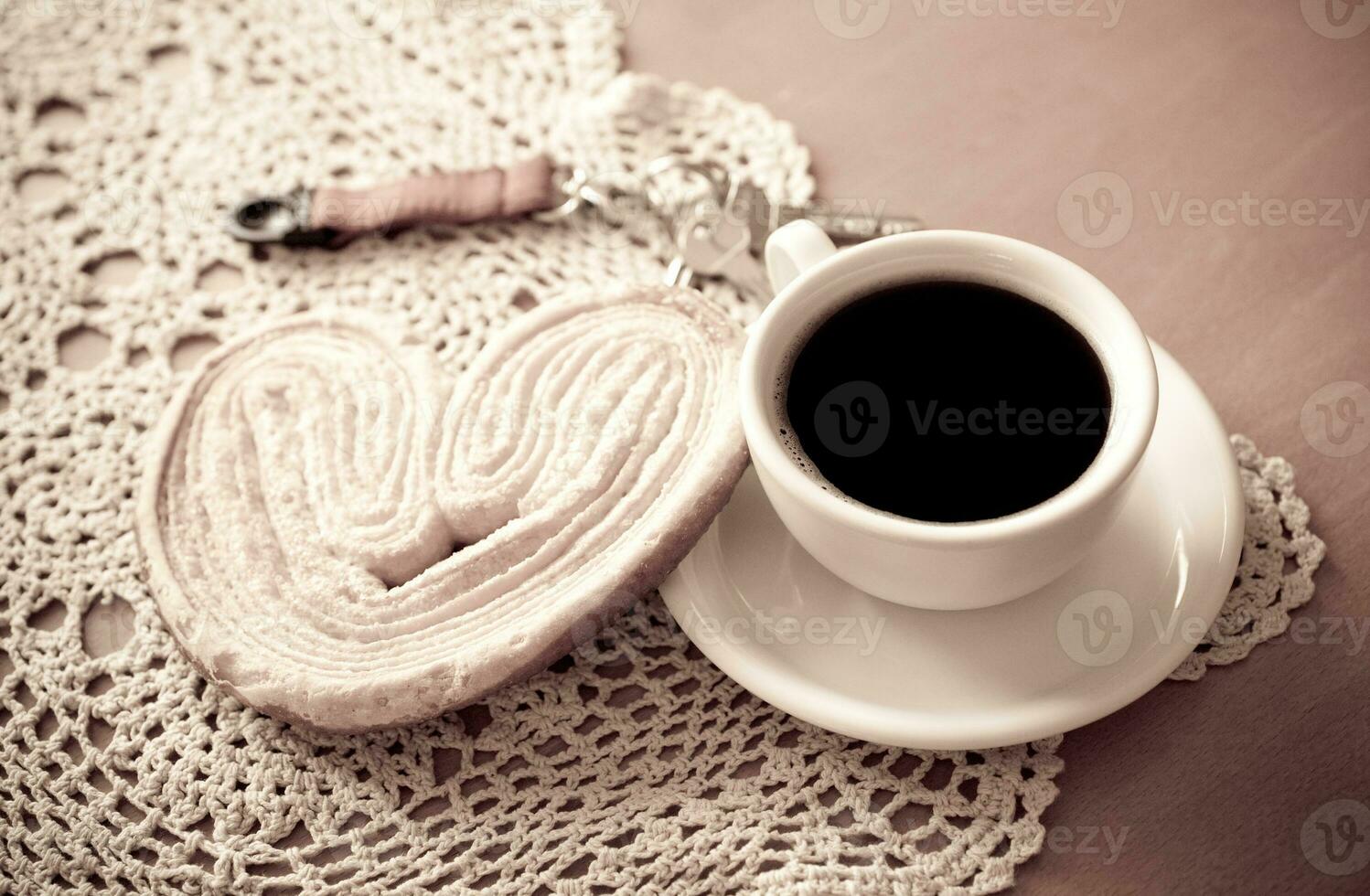 white cup of black coffee and a sweet buttery cookie on the table photo