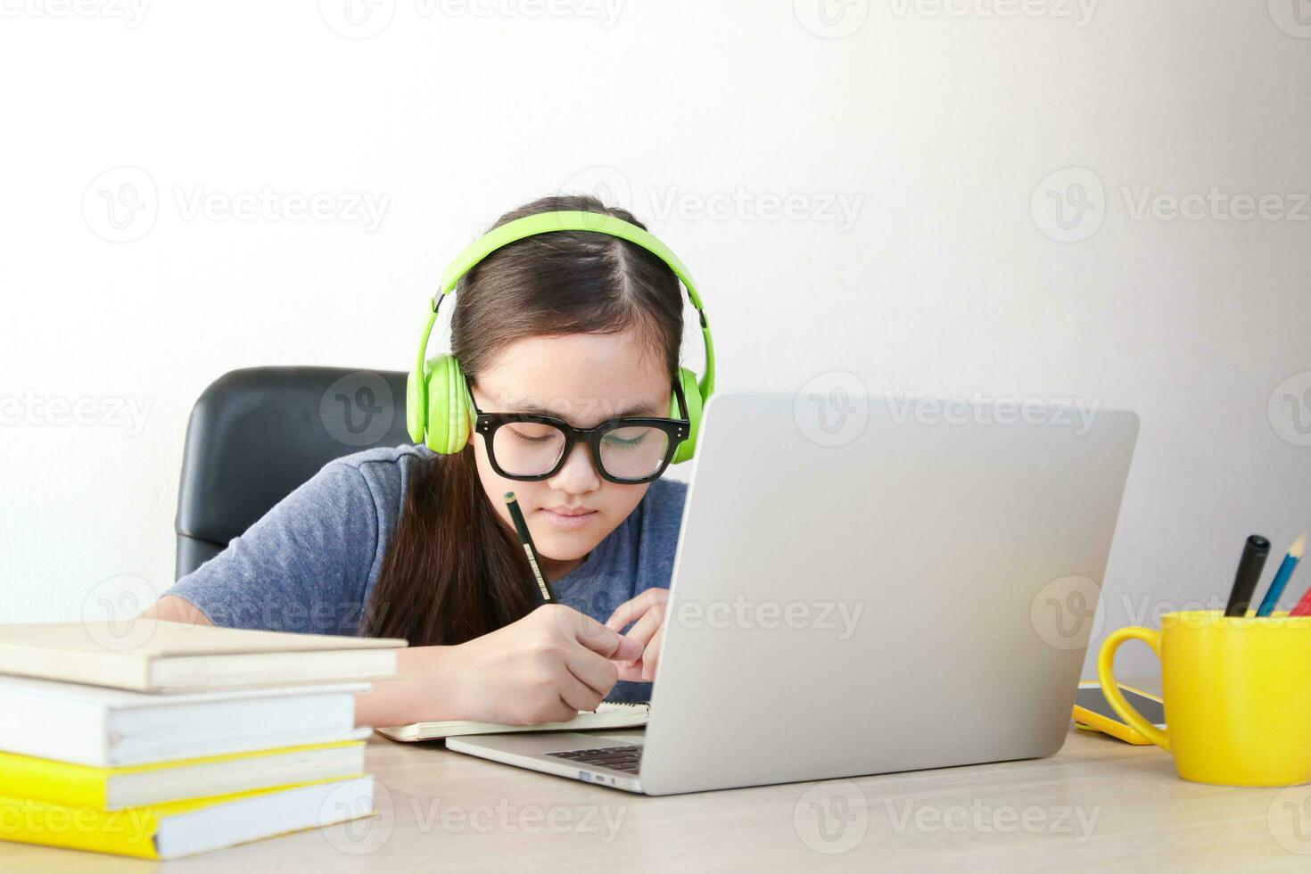 Asian schoolgirl Learn online from home through video calls. Using a laptop computer to communicate with teachers. Concept of online education. Social distancing to reduce the spread of coronavirus. photo