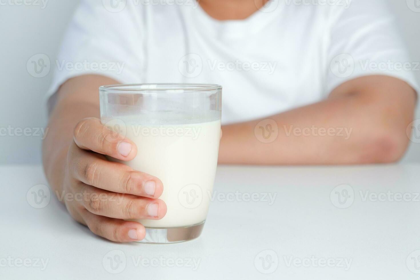 Fat boy holding a full glass of milk. Children are drinking milk. The concept of healthy eating It is beneficial for the growth of children. photo