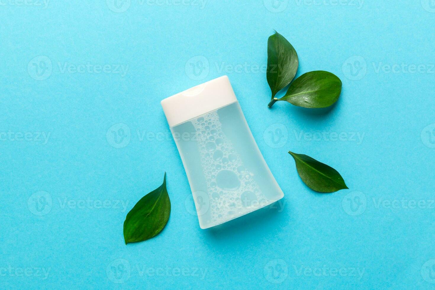 Organic cosmetic products with green leaves on color background. Flat lay. photo