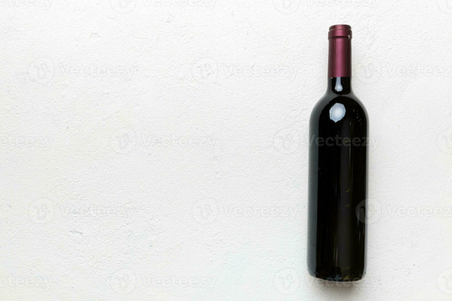 One Bottle of red wine on colored table. Flat lay, top view wth copy space photo