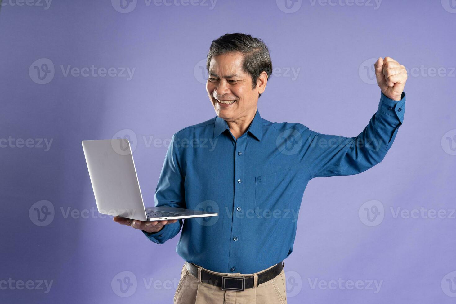 retrato de medio Envejecido asiático negocio hombre posando en púrpura antecedentes foto