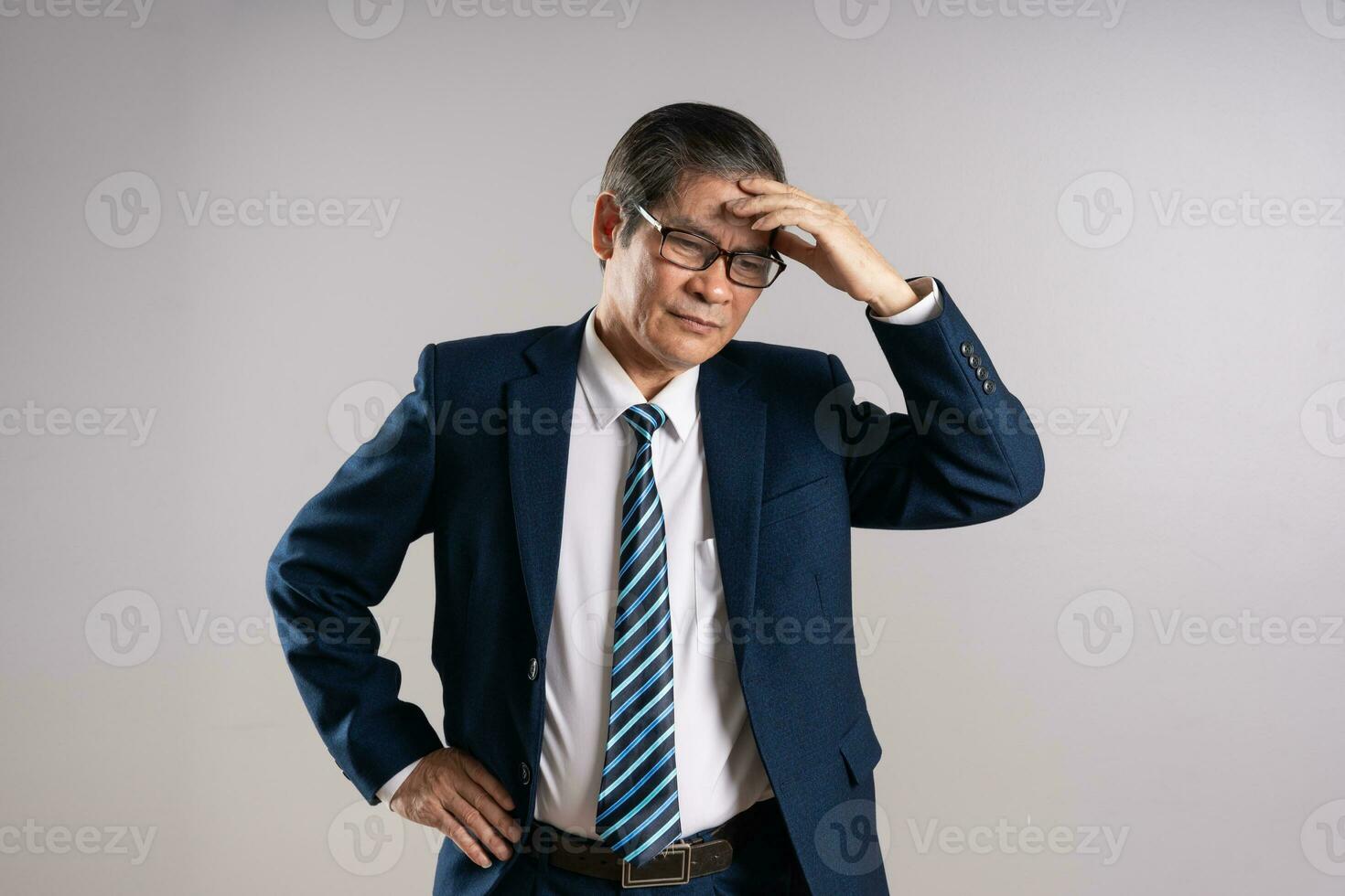 retrato de un mayor asiático empresario, posando en un azul antecedentes foto