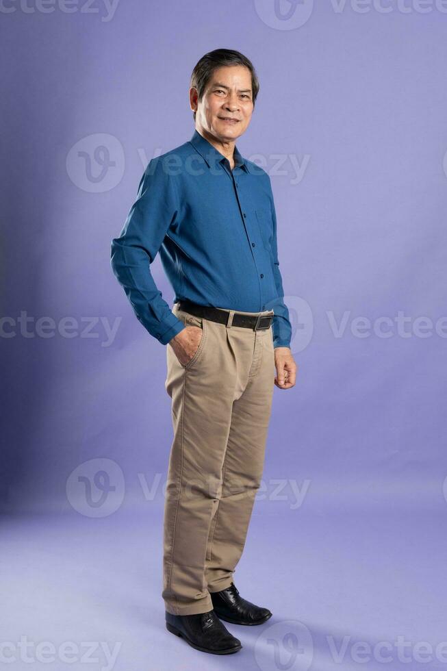 portrait of middle aged asian business man posing on purple background photo