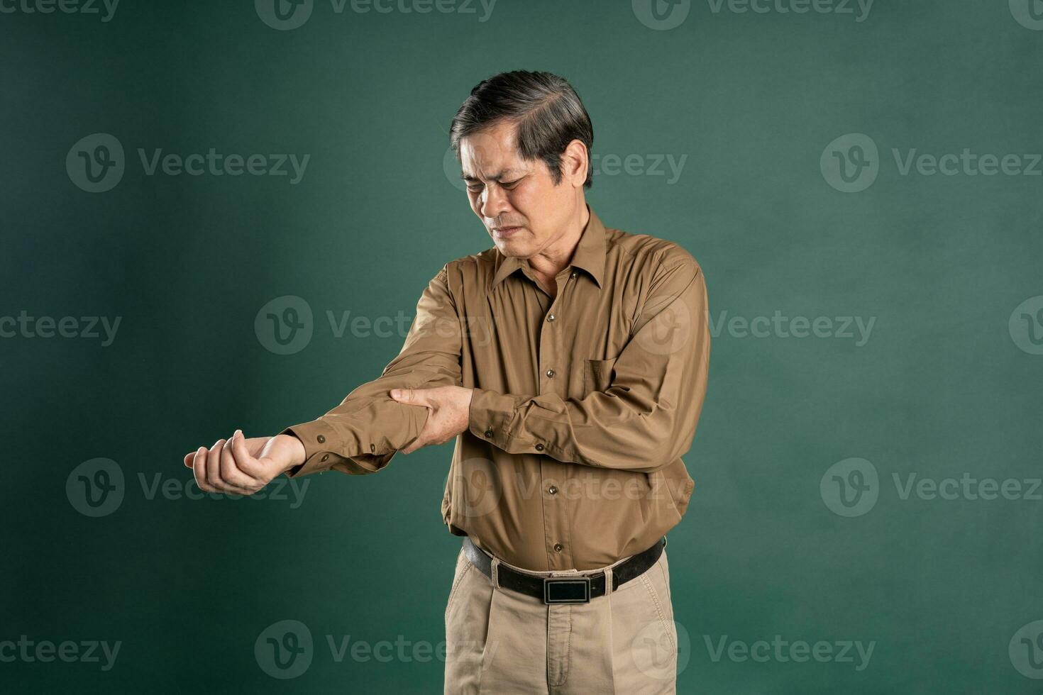 portrait of middle aged asian man posing on blue background photo