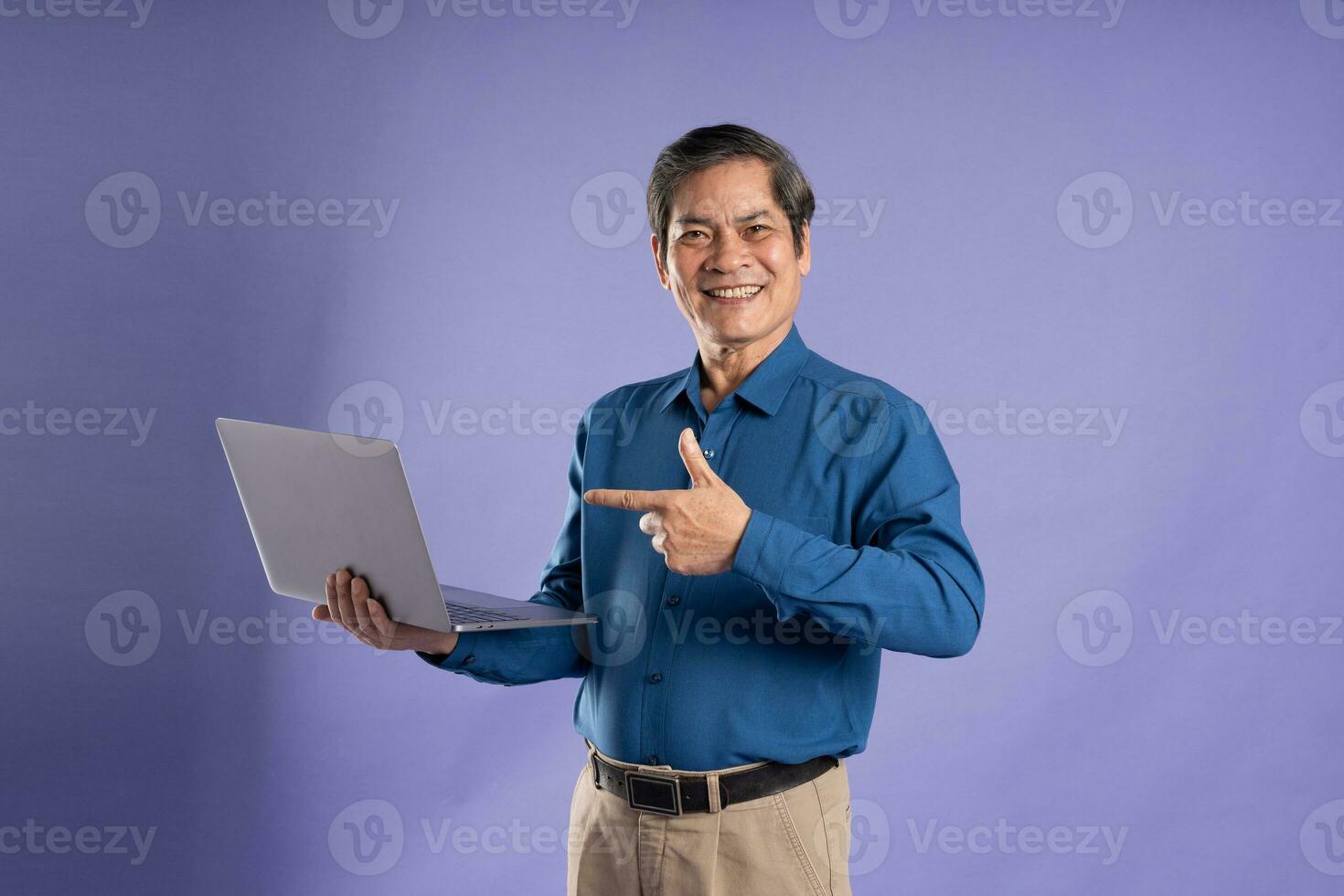retrato de medio Envejecido asiático negocio hombre posando en púrpura antecedentes foto
