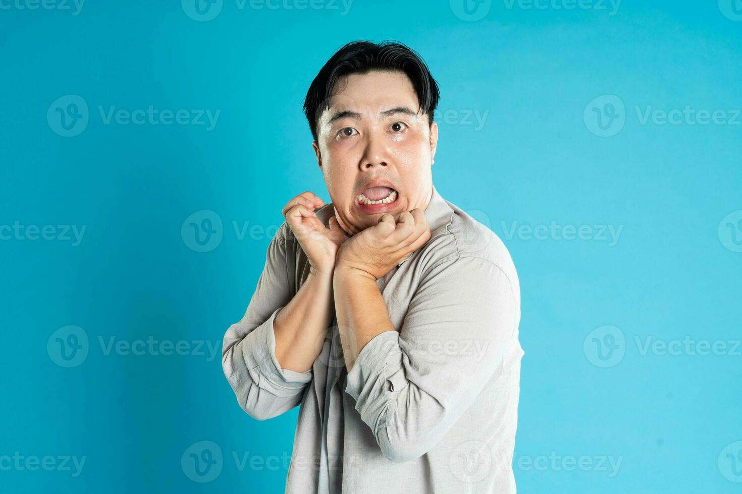 Portrait of an Asian guy posing on a blue background photo