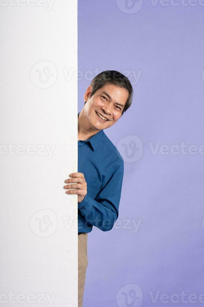 portrait of middle aged asian business man posing on purple background photo