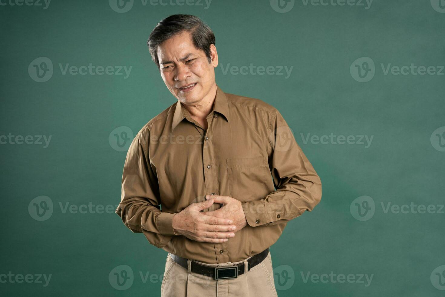 portrait of middle aged asian man posing on blue background photo