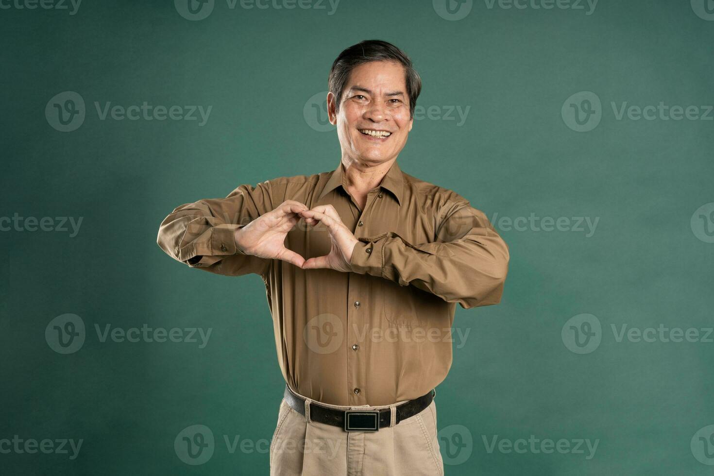 portrait of middle aged asian man posing on blue background photo