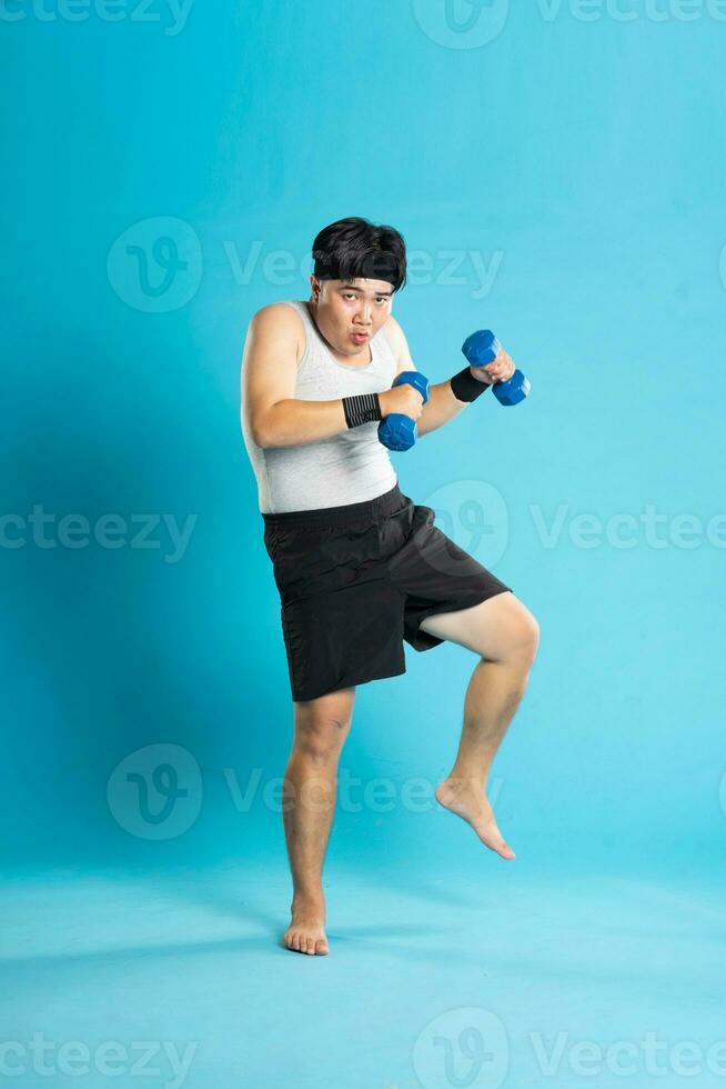 imagen de asiático hombre hacer ejercicio en azul antecedentes foto