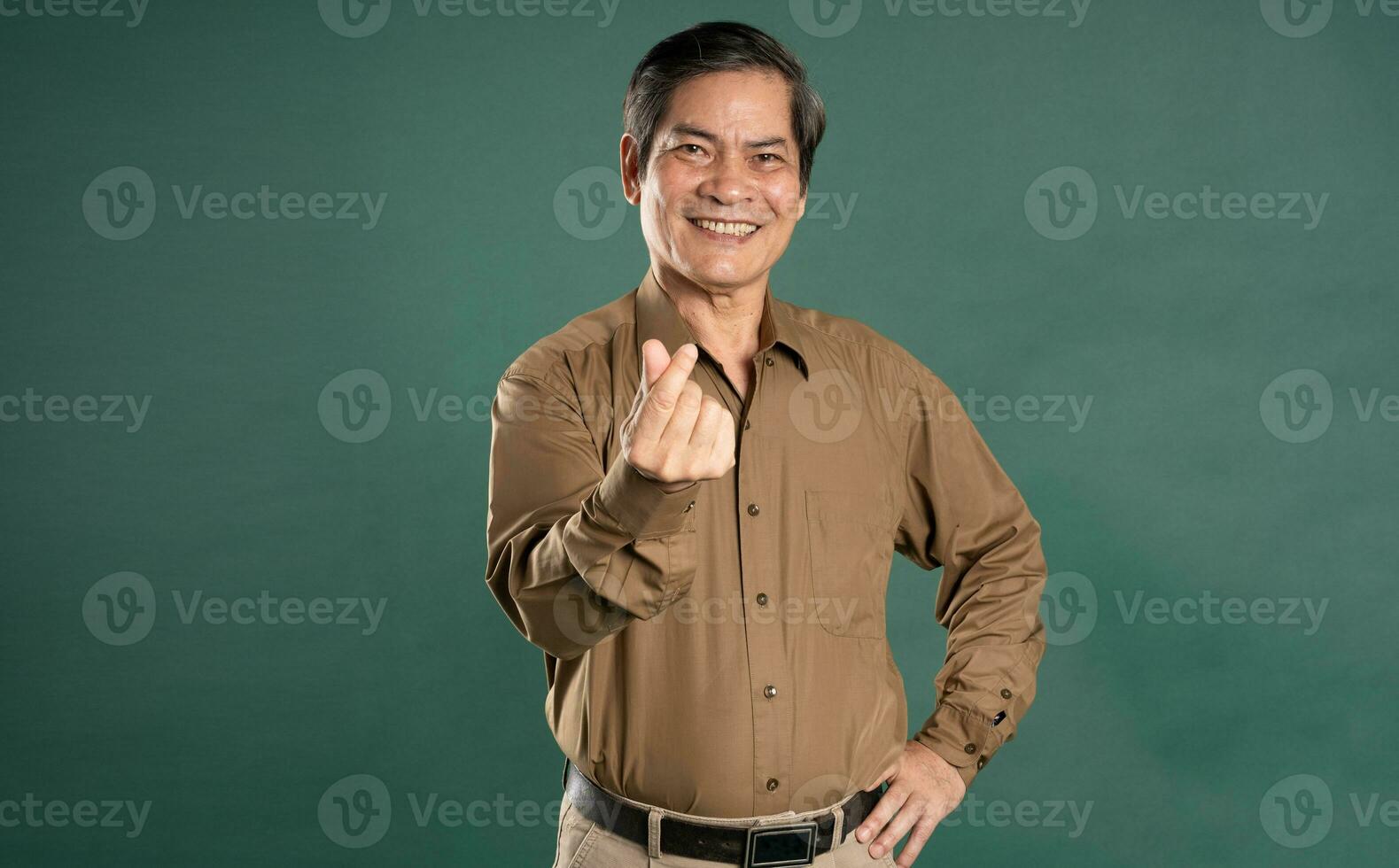 portrait of middle aged asian man posing on blue background photo