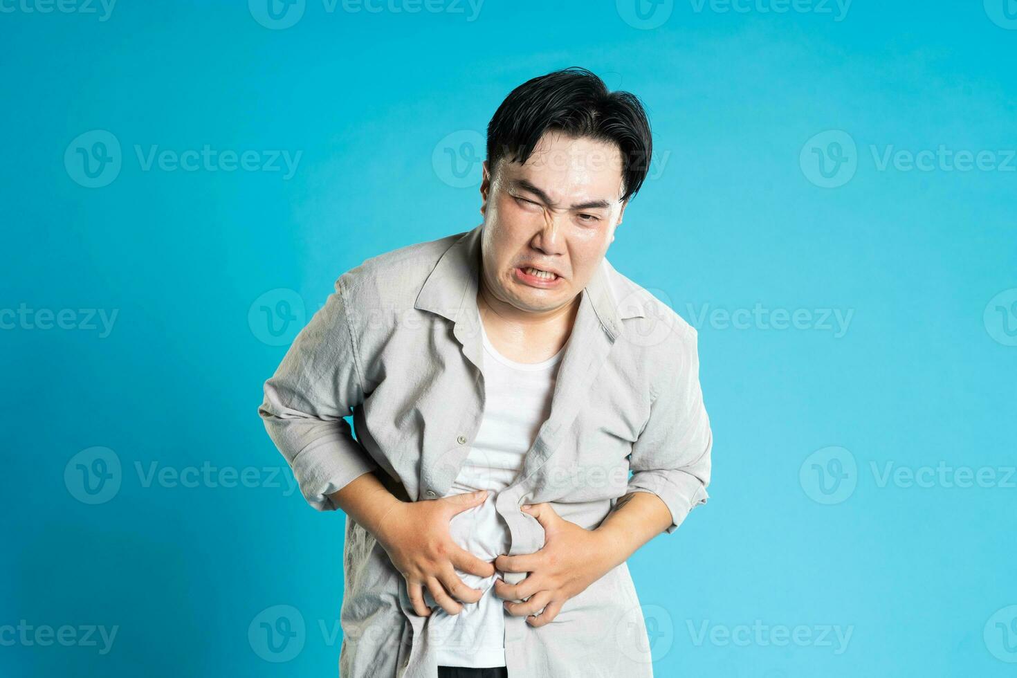 Image of Asian man having health problems, isolated on blue background photo