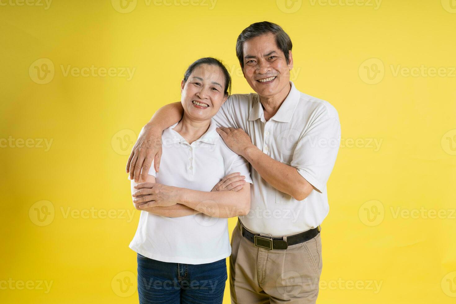 portrait of middle aged asian couple posing on yellow background photo