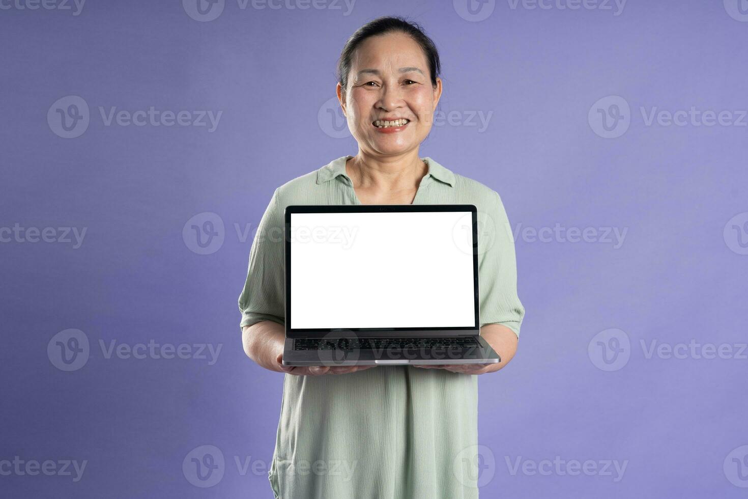 Gangang middle-aged Asian female portrait posing on purple background photo