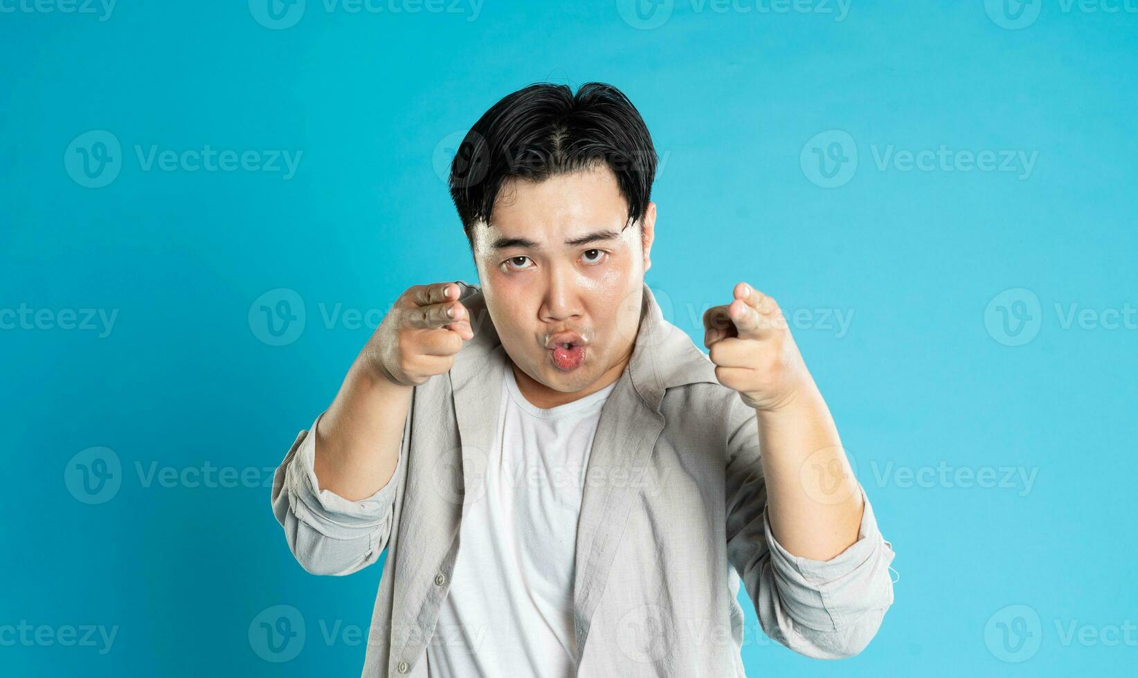 Portrait of an Asian guy posing on a blue background photo