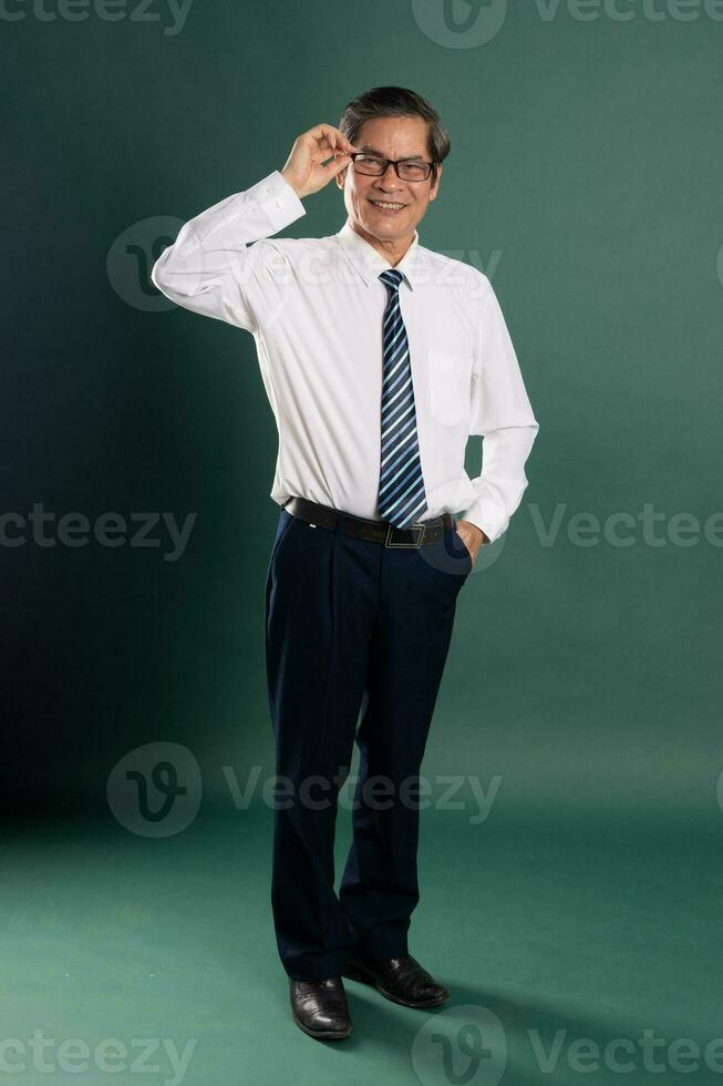 portrait of middle aged asian man posing on blue background photo