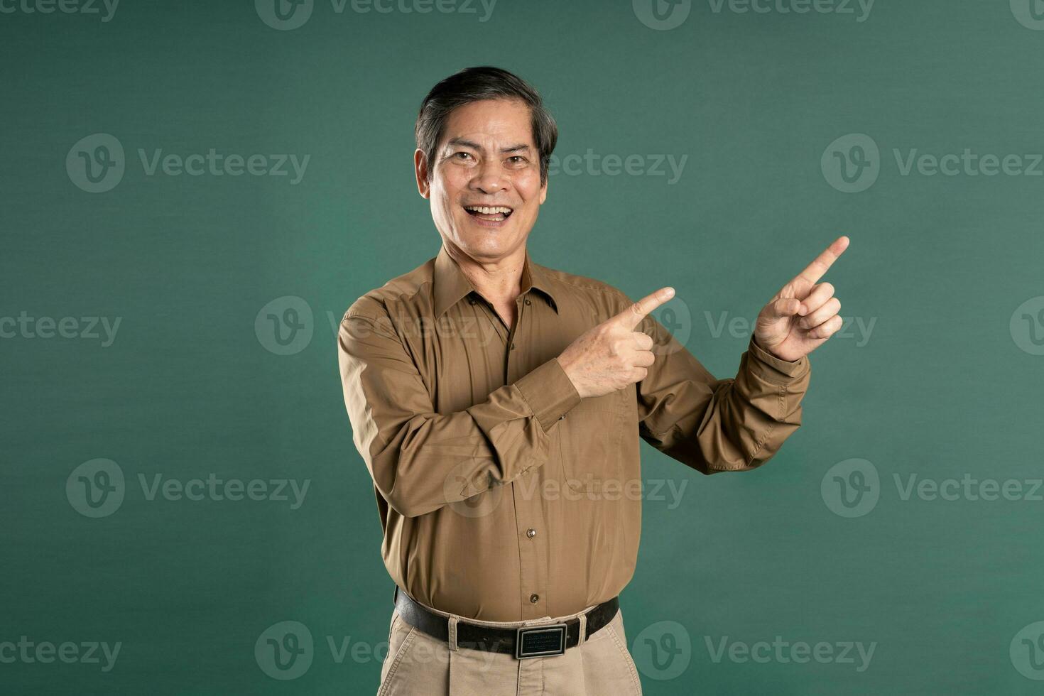 portrait of middle aged asian man posing on blue background photo