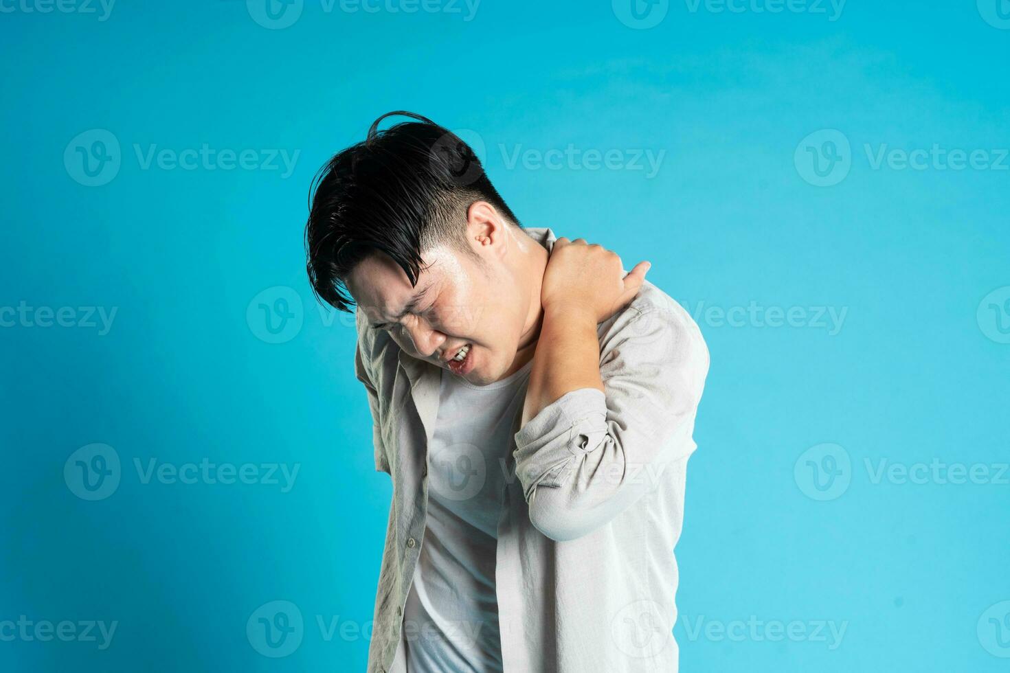 imagen de asiático hombre teniendo salud problemas, aislado en azul antecedentes foto