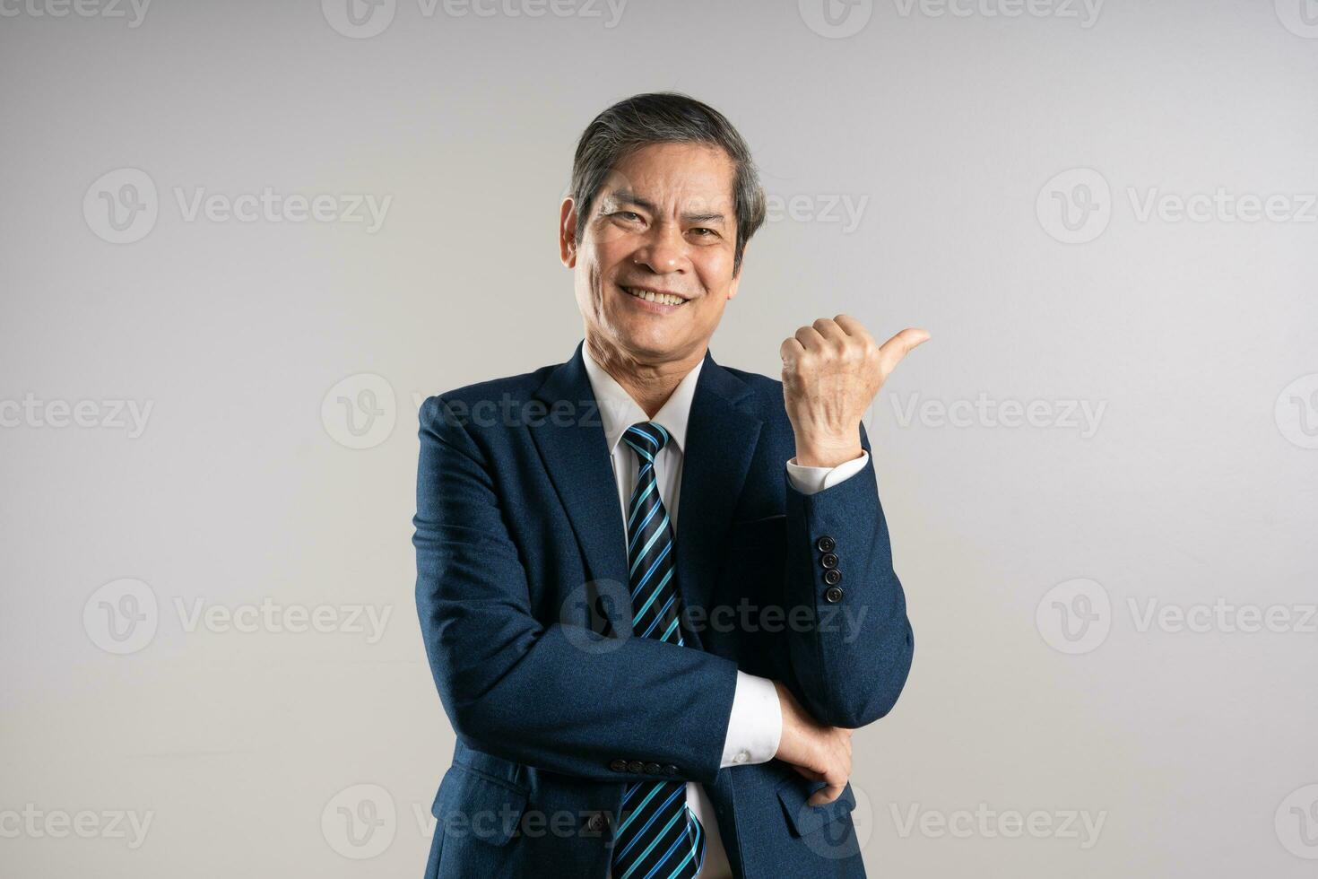 retrato de un mayor asiático empresario, posando en un azul antecedentes foto