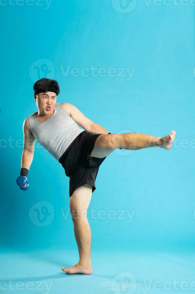 Image of Asian man exercising on blue background photo