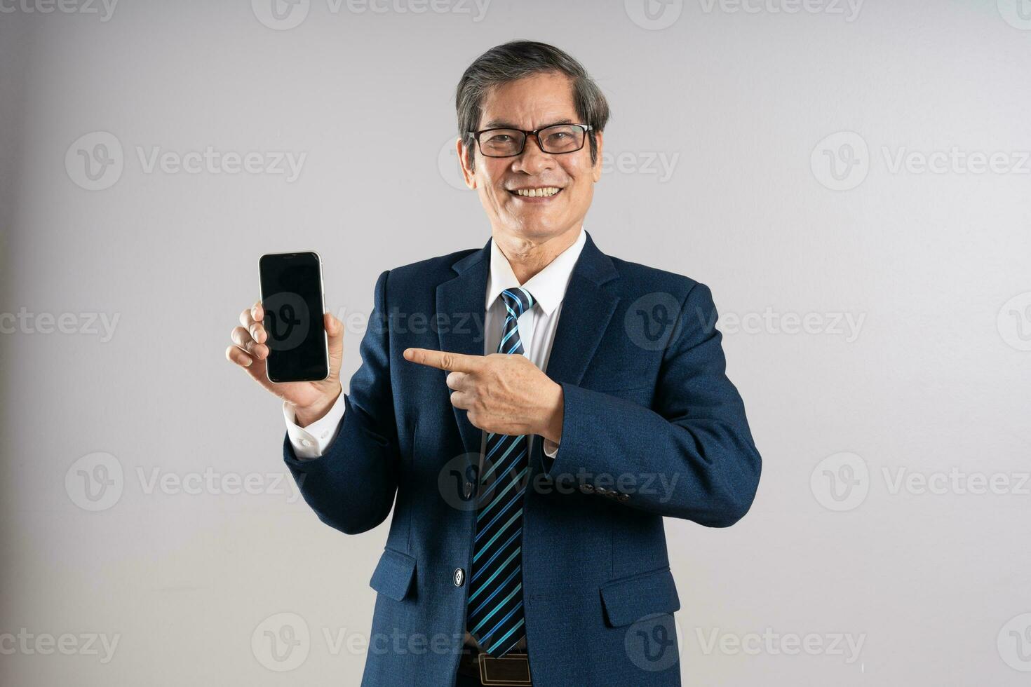 Portrait of an elderly Asian businessman, posing on a blue background photo