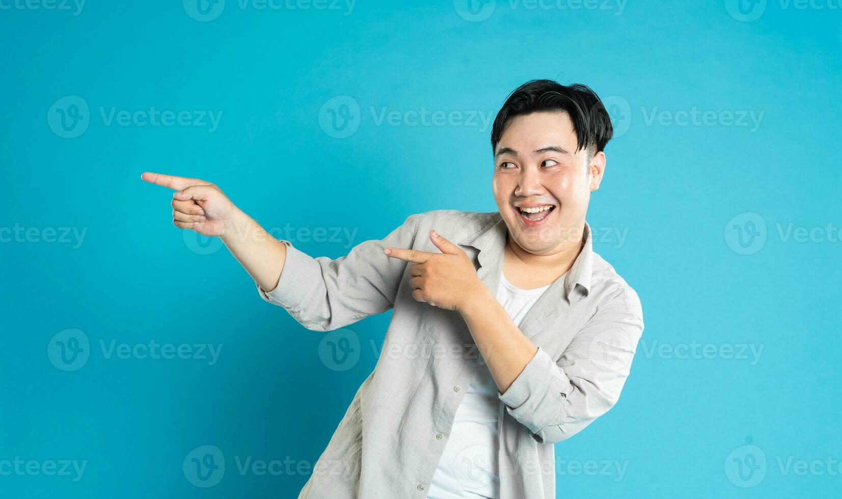 Portrait of an Asian guy posing on a blue background photo