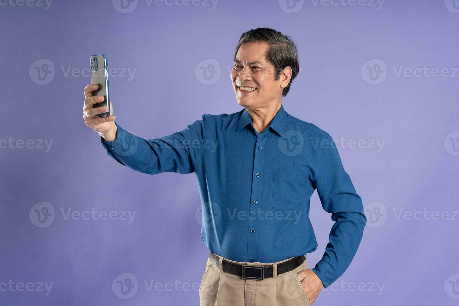 portrait of middle aged asian business man posing on purple background photo