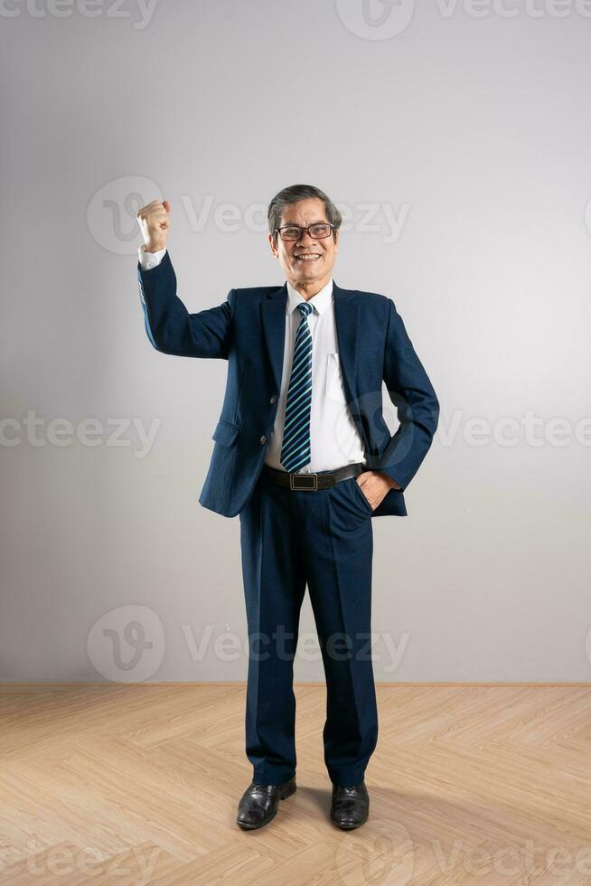 retrato de un mayor asiático empresario, posando en un azul antecedentes foto