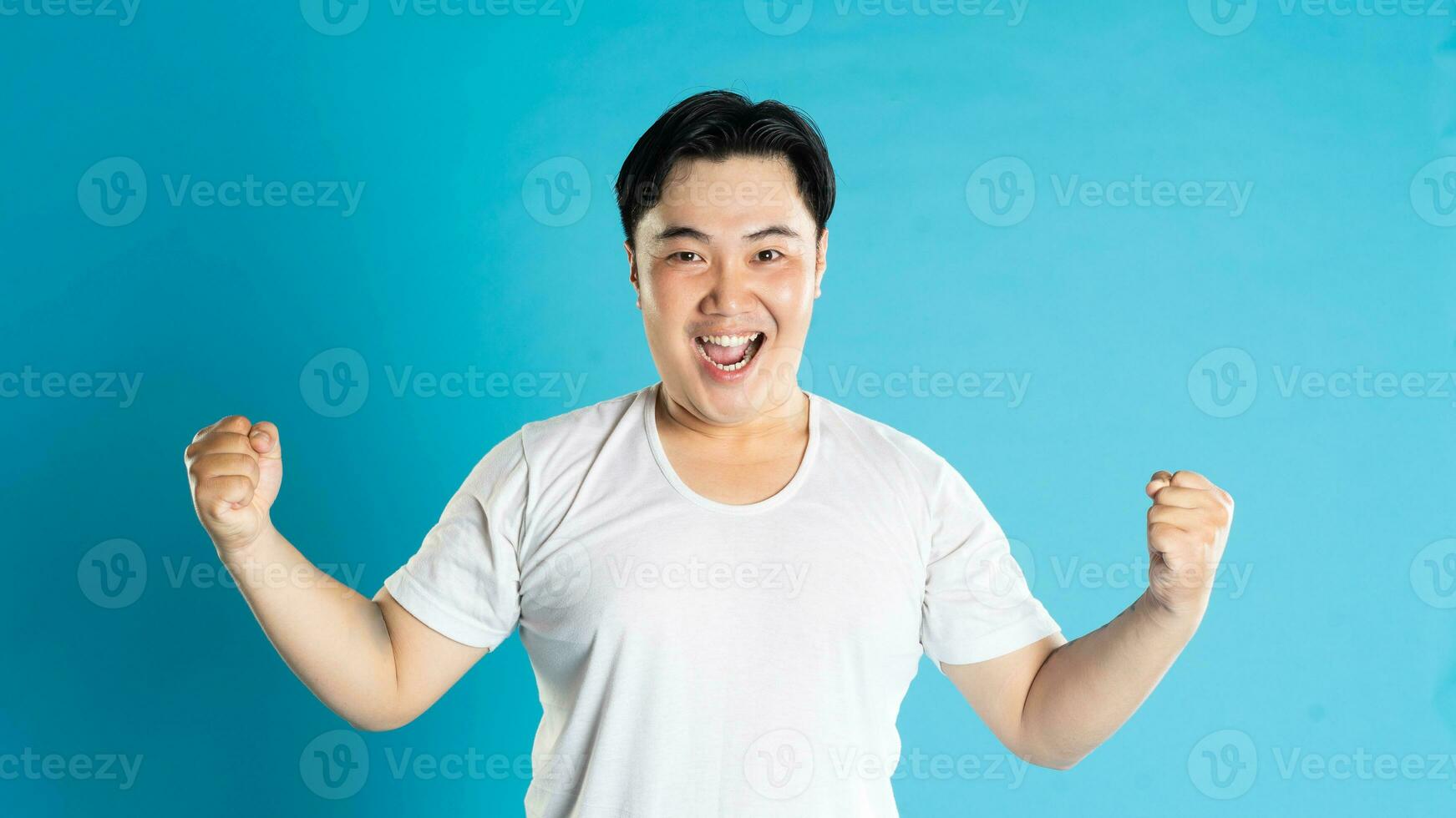 Portrait of an Asian guy posing on a blue background photo