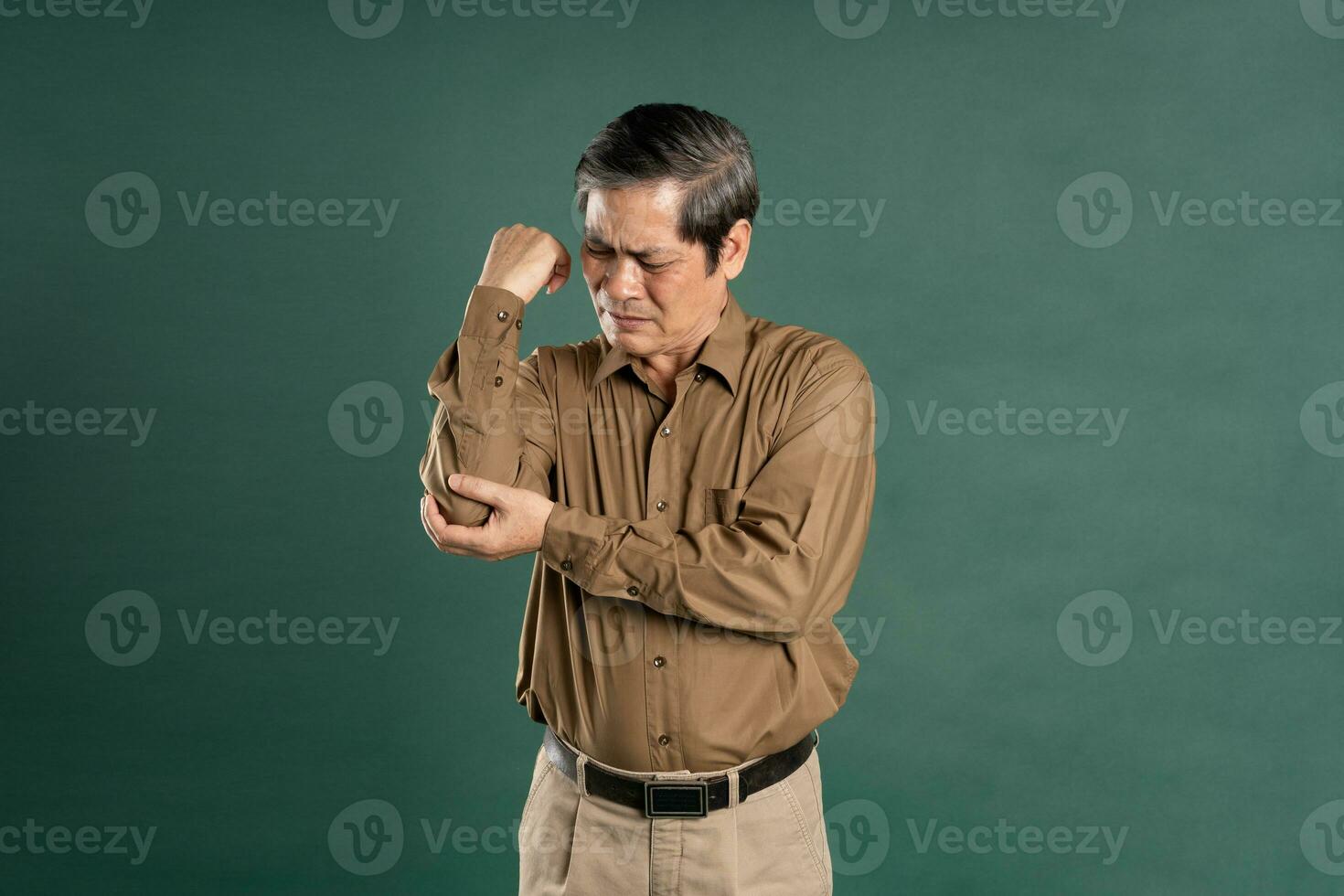 portrait of middle aged asian man posing on blue background photo