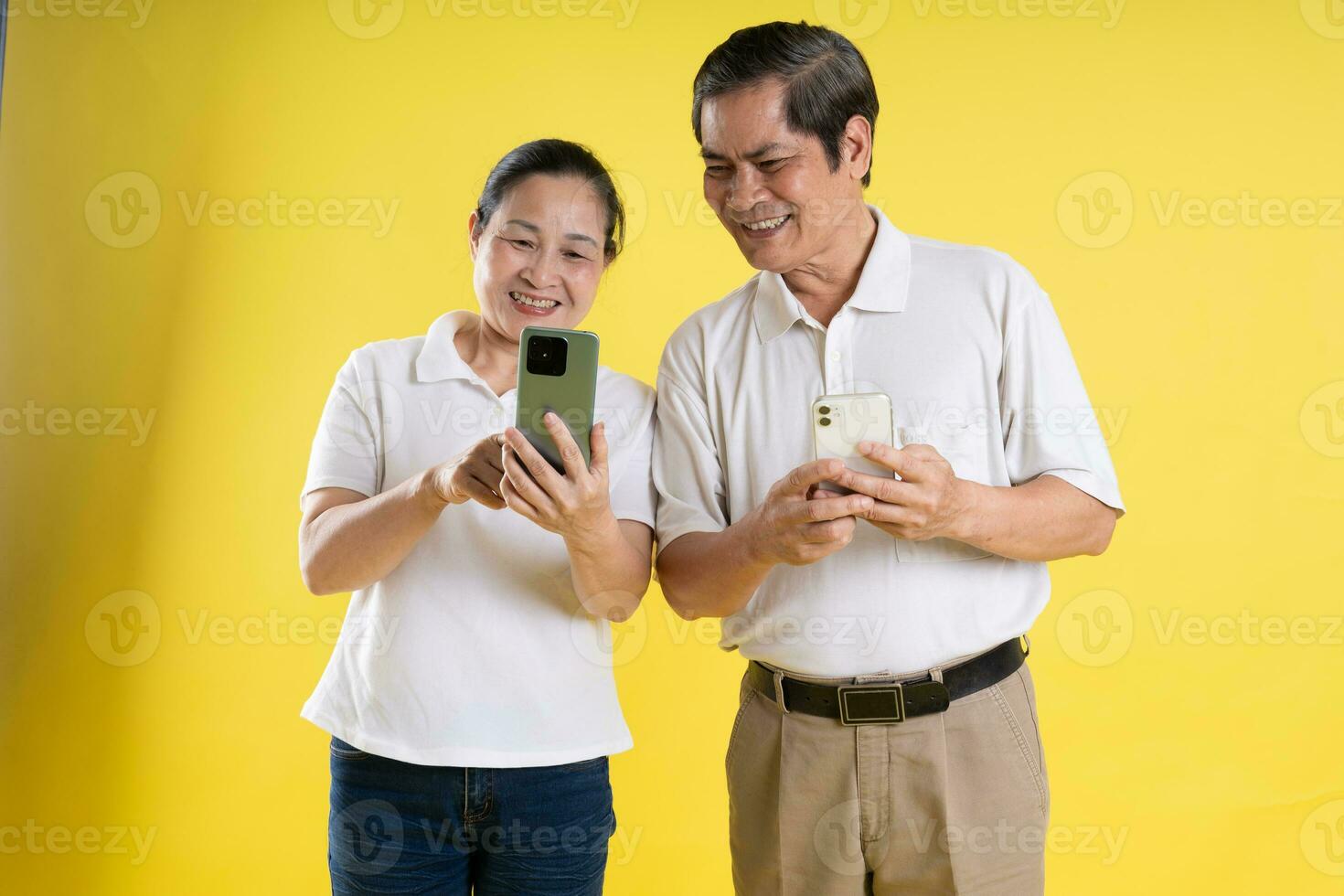 portrait of middle aged asian couple posing on yellow background photo