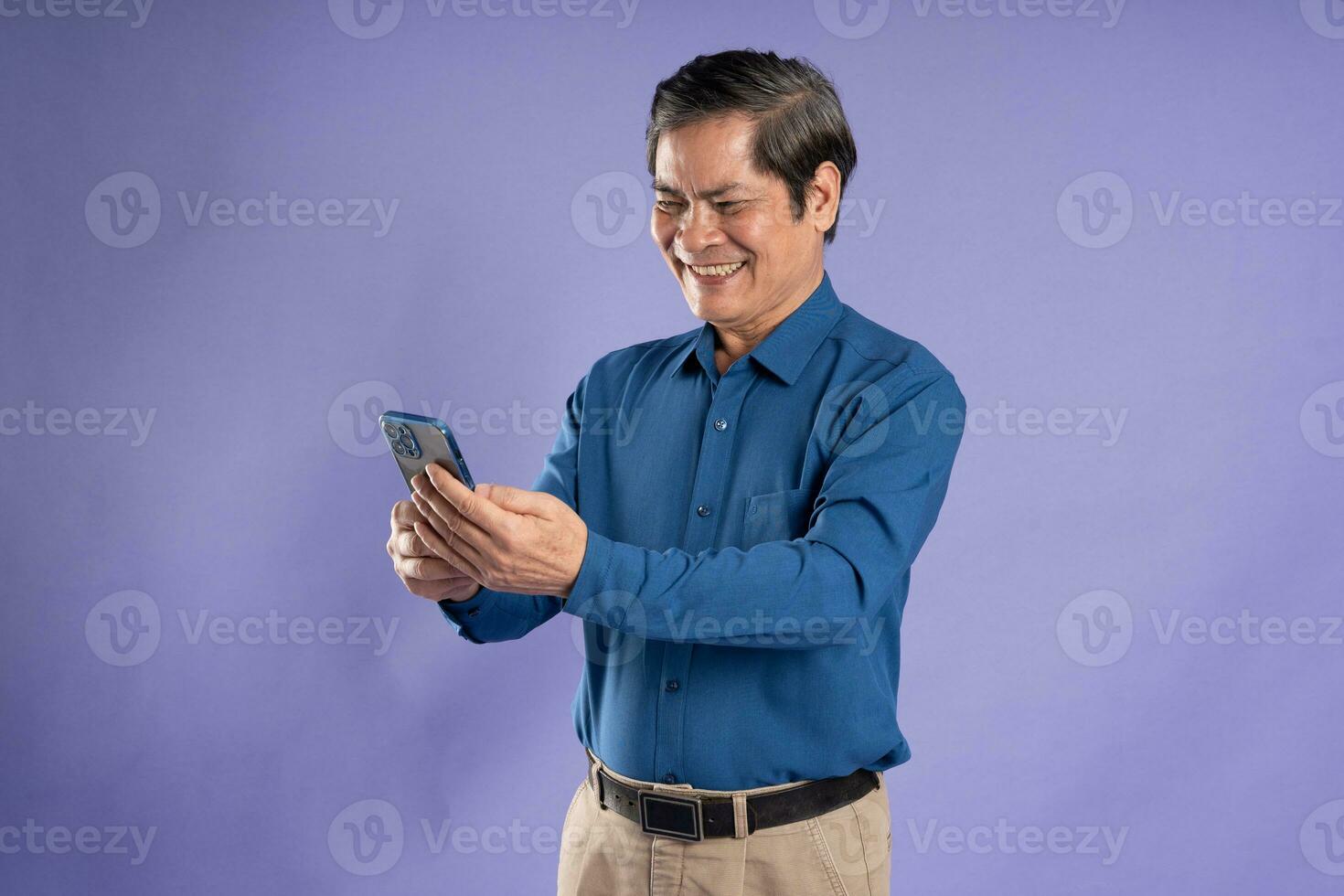 portrait of middle aged asian business man posing on purple background photo