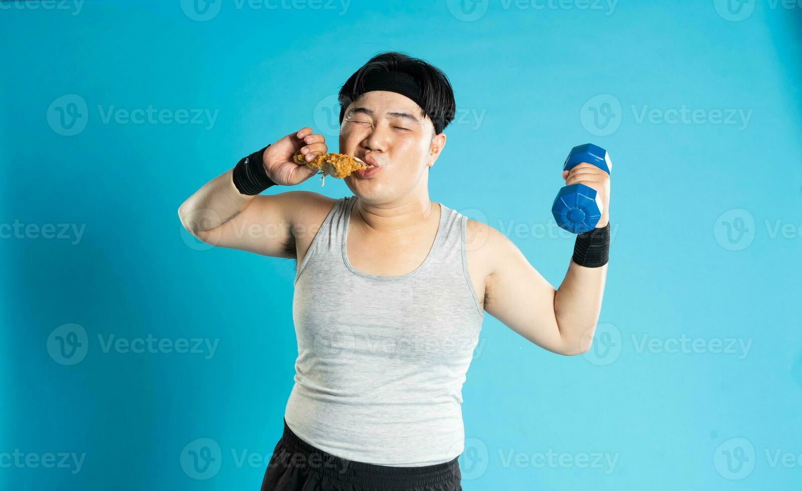 Image of Asian man exercising on blue background photo