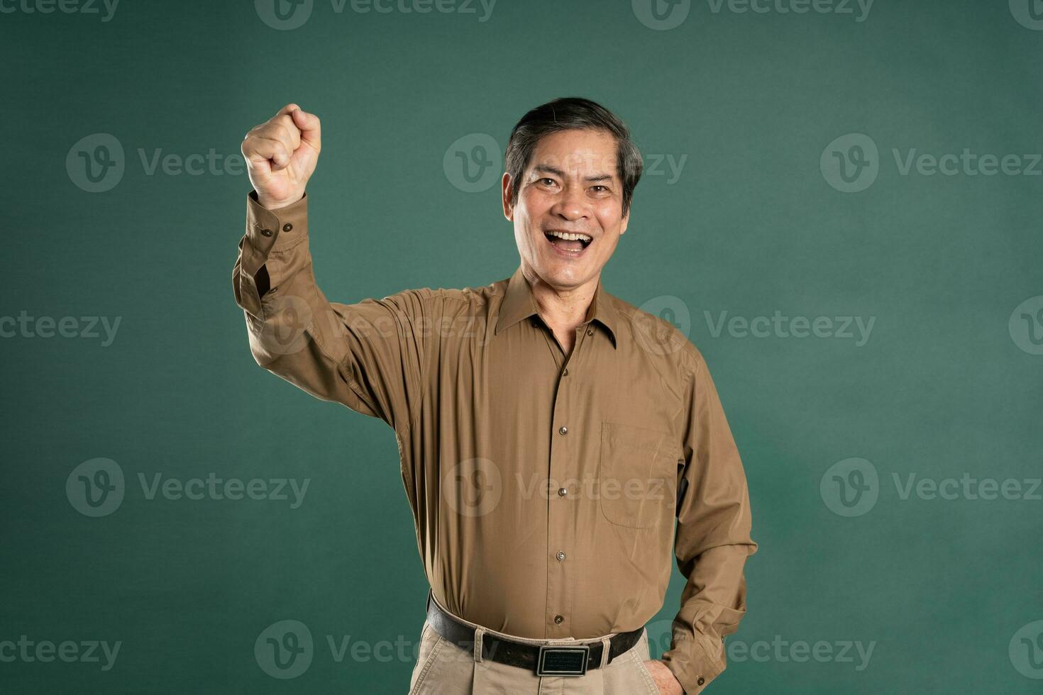 portrait of middle aged asian man posing on blue background photo