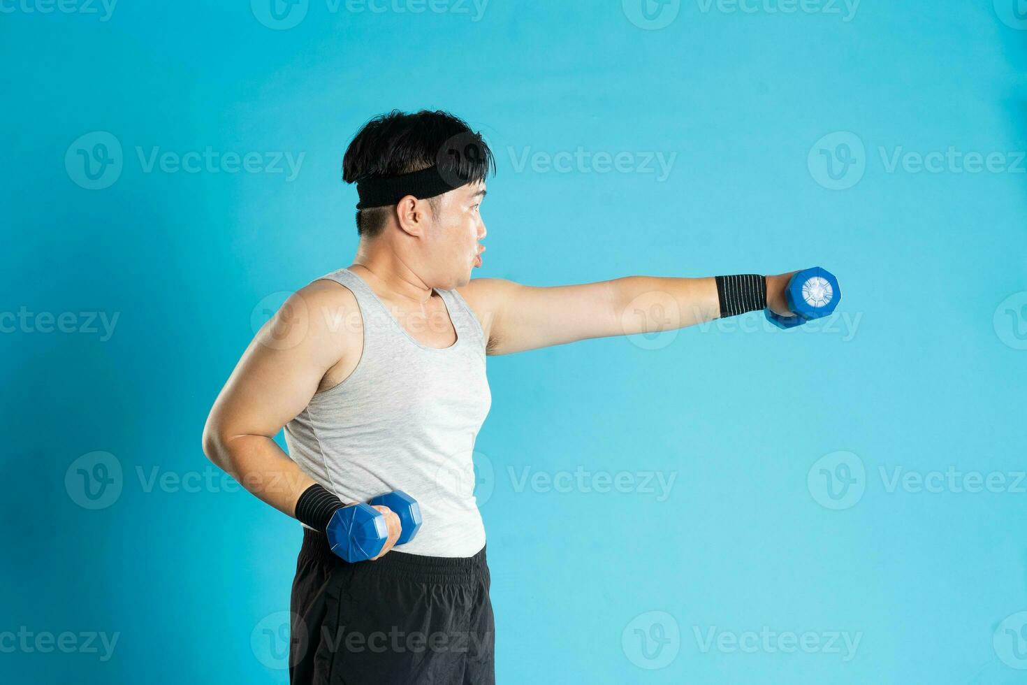 Image of Asian man exercising on blue background photo