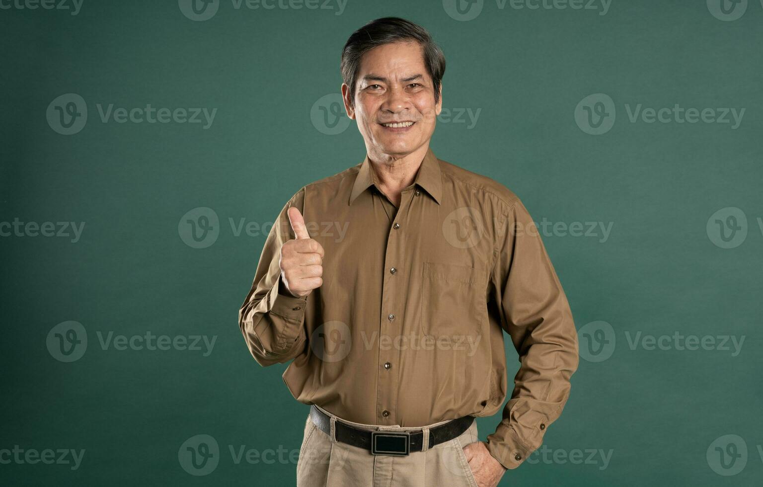 portrait of middle aged asian man posing on blue background photo