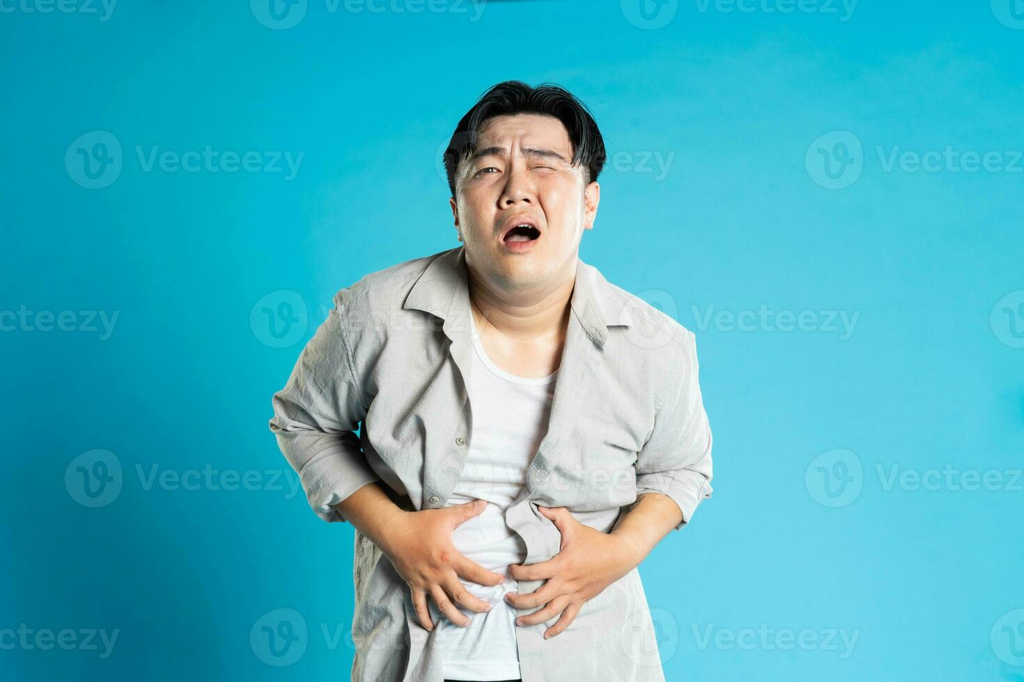 imagen de asiático hombre teniendo salud problemas, aislado en azul antecedentes foto