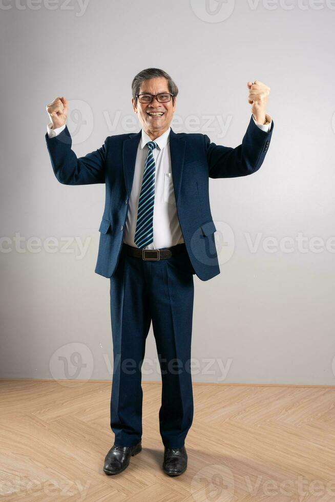 retrato de un mayor asiático empresario, posando en un azul antecedentes foto