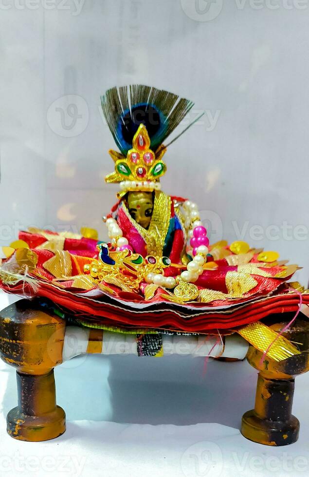 Lord Krishna also known as laddu gopal sculpture in beautiful clothes selective focus photo