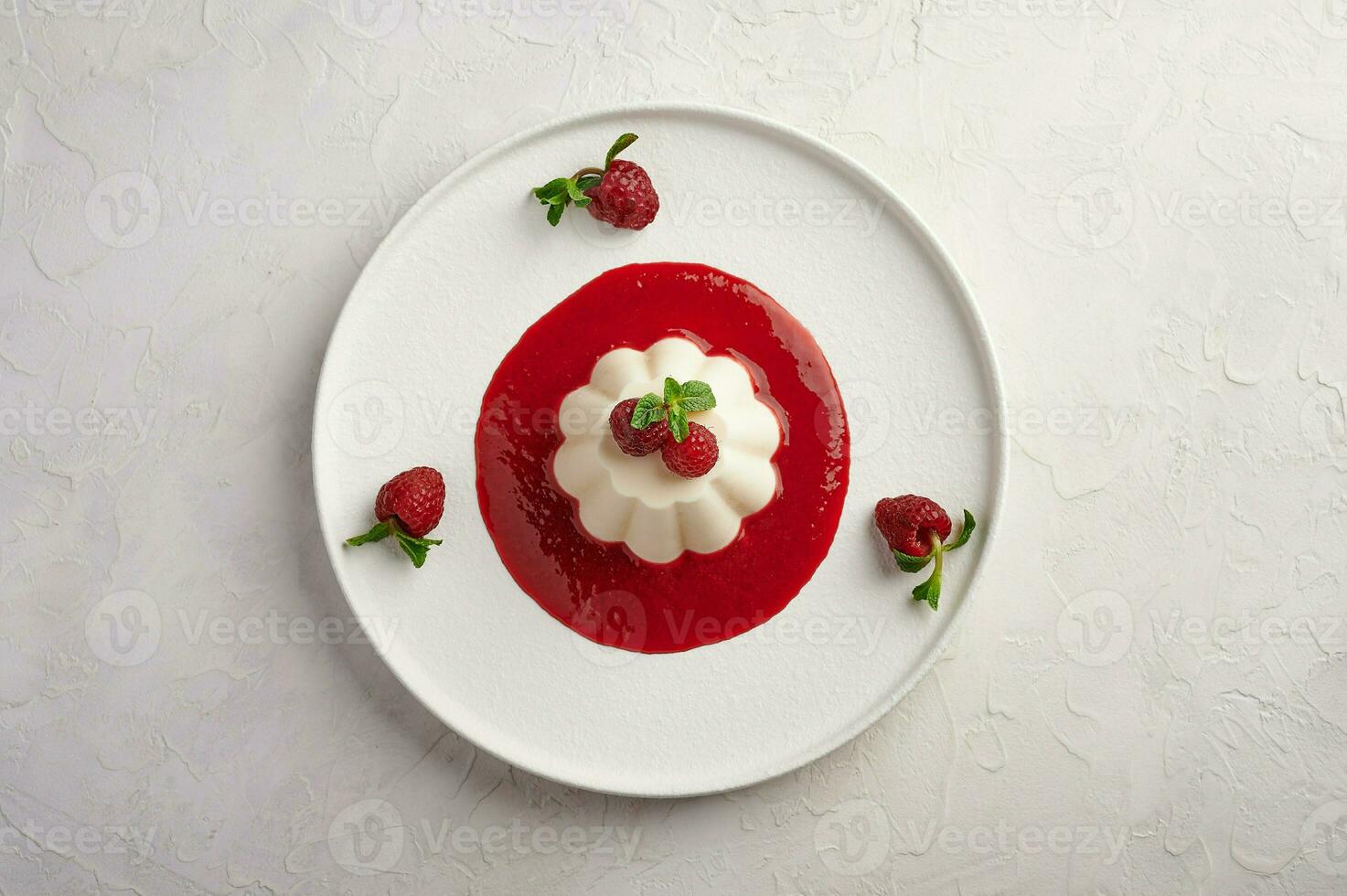 Panna cotta with raspberry syrup, pistachios,berries and mint photo