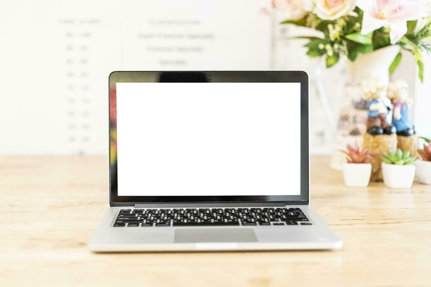 Mockup image of laptop with blank white screen on wooden table of In the coffee shop. photo