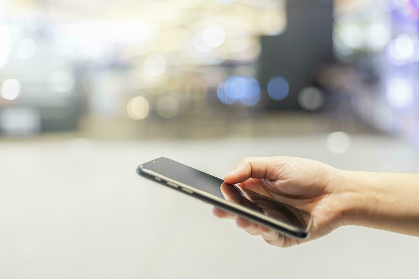 Close-up of female working using smartphone blurred images in Abstract inside shopping mall background. photo