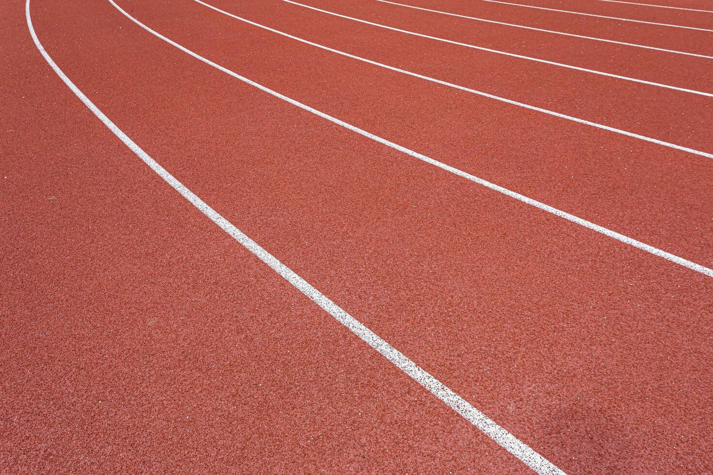 blanco líneas de estadio y textura de corriendo pista rojo caucho pistas de carreras en al aire libre estadio son 8 pista y verde césped campo,vacío atletismo estadio con pista. foto