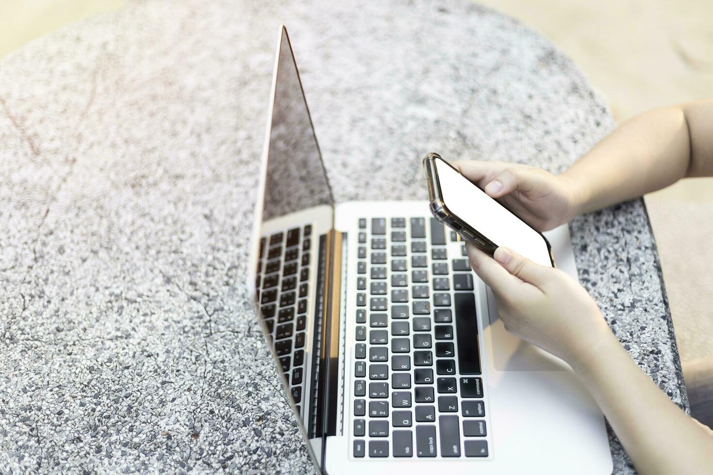 Close-up of business female working with laptop and smartphone in at the park on office outdoor. photo